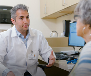 Dr. Matthew Furman, Attending, Surgical Oncology, consulting with patient.