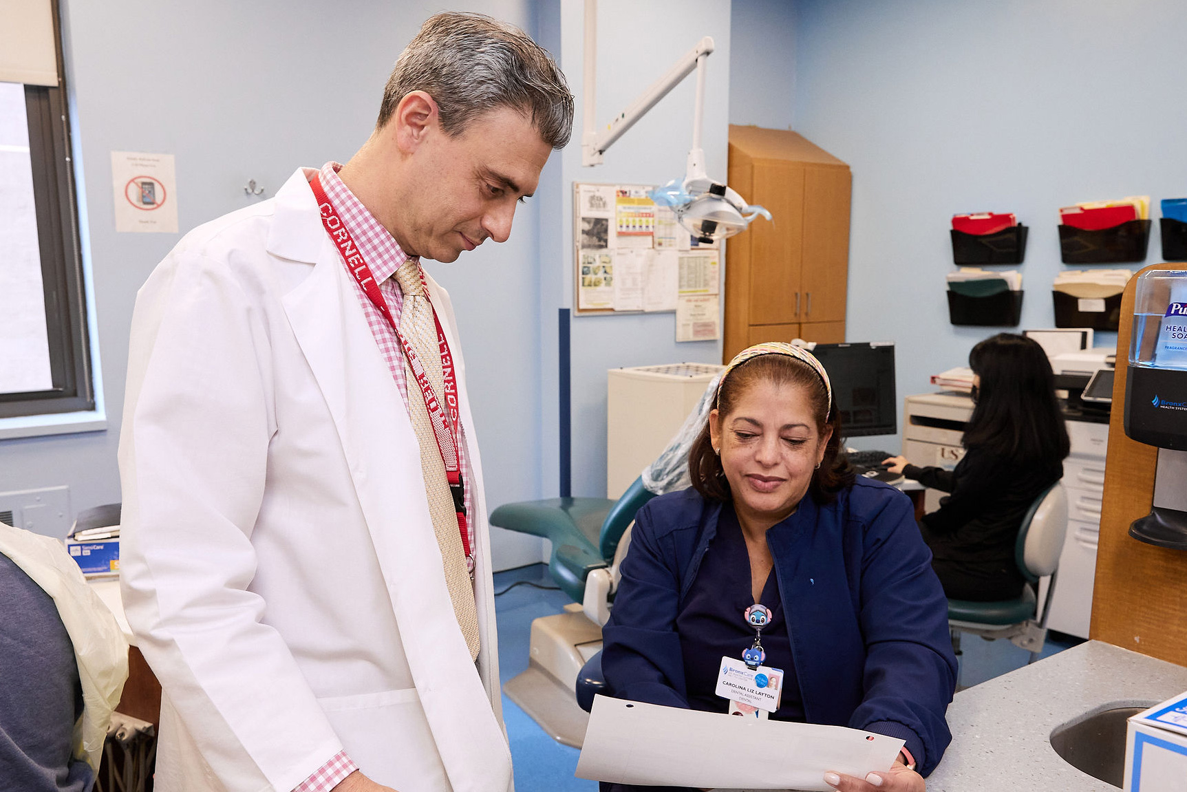 Dr. Bradley Schnebel, Attending, Orthodontics, reviewing patient information with Carolina Liz-Layton, Dental Assistant.
