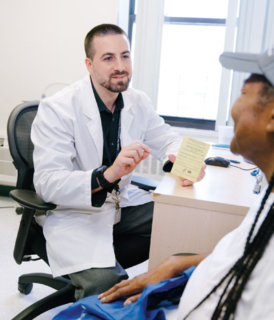 Dr. Paul Kelly, Director, Center for Travel Medicine, instructing patient.