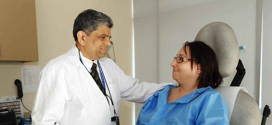 Dr. Ajay Shah, Vice Chairman/Program Director, Surgery, comforting patient.