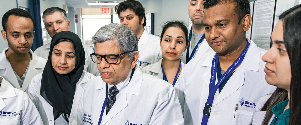 Dr. Ajay Shah, Vice Chairman/Residency Program Director, Surgery, reviewing patient record with surgical residents during teaching rounds.